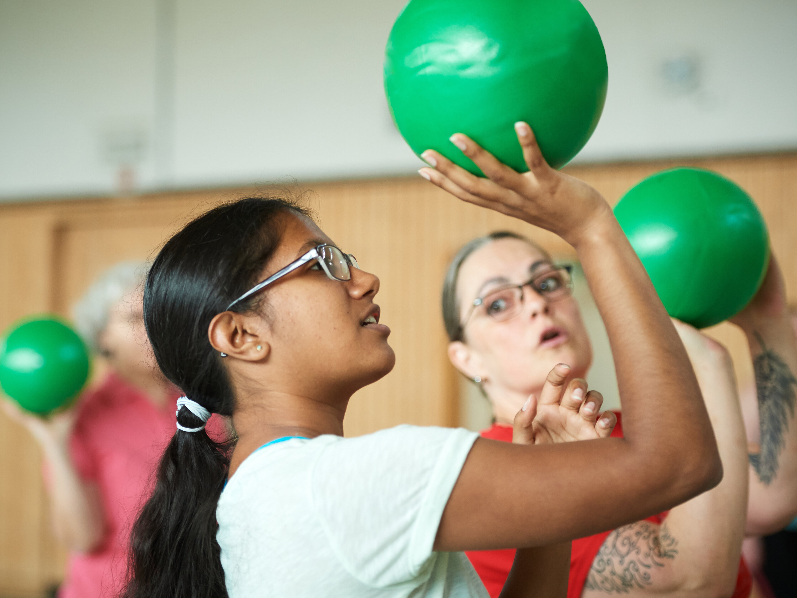 Menschen beim Funktionstraining mit grünen Bällen